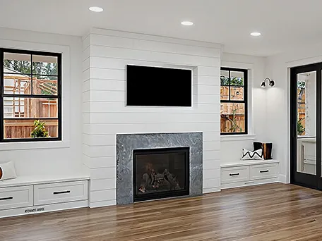Modern living room with fireplace, hardwood floors, and large windows